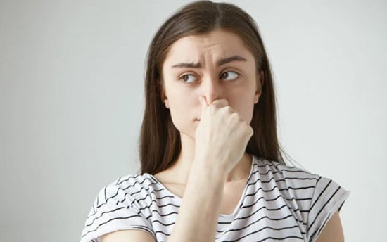 What to Do if Smell Doesn't Go Away? Woman holding nose