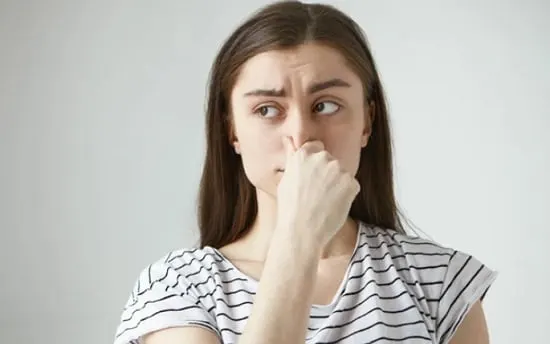 What to Do if Smell Doesn't Go Away? Woman holding nose